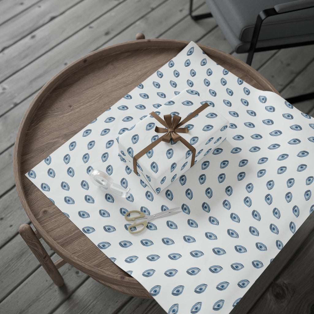Wooden tray with a white paper featuring blue patterns and scissors on a wooden surface.